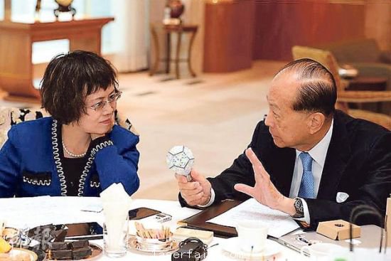 李嘉誠（右）在接受媒體訪問時(shí)指出，長實(shí)集團(tuán)以香港為基地，常常積極在港尋找投資機(jī)會(huì)，但是政府很多政策，需時(shí)消化。圖為他向財(cái)新傳媒總編輯胡舒立介紹他本周的“最愛”納米LED燈泡。圖片來源：香港明報(bào)